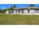 Newly renovated gray house with a lush green lawn and driveway at 4284 Watova Ave, North Port, FL 34286