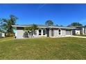 Gray house with arched windows, palm trees, and a grassy yard at 4284 Watova Ave, North Port, FL 34286