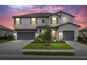 Two-story house with gray siding, two-car garage, and landscaped yard at dusk at 4886 Seafoam Trl, Bradenton, FL 34211