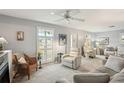 Bright living room with comfy seating, a ceiling fan, and neutral decor at 6380 S Biscayne Dr, North Port, FL 34287