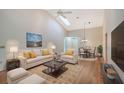 Bright living room with hardwood floors, staged furniture, and a view into the dining area at 6723 Approach Rd # 35, Sarasota, FL 34238
