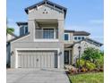 Two-story house with gray siding, balcony, and three-car garage at 8273 Shooting Star Rd, Sarasota, FL 34241