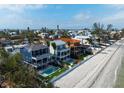 Aerial view showcasing beautiful beachfront homes, each with pools and manicured lawns along the white sandy beach at 915 N Shore Dr, Anna Maria, FL 34216