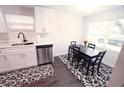 Kitchen with white cabinets, stainless steel appliances, and a dining area at 1317 E Osborne Ave, Tampa, FL 33603