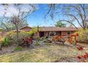 Beautiful single-story home with a vibrant garden, mature trees, and a meticulously kept lawn at 2218 Shadow Oaks Rd, Sarasota, FL 34240