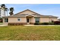 Back view of a tan house with a grassy lawn and some shrubs at 2906 Captains Ct, Palmetto, FL 34221