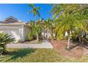 Landscaped front yard with palm trees and a brick walkway leading to the house at 408 Golden Harbour Trl, Bradenton, FL 34212