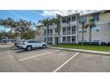 Exterior view of a three-story condo building with beige siding, white trim, and screened-in porches and on-site parking at 4802 51St W St # 1118, Bradenton, FL 34210