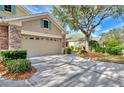 Two-car garage with stone accents and neatly manicured landscaping at 4914 Lakescene Pl, Sarasota, FL 34243