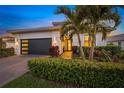Modern house exterior with a dark garage door and manicured landscaping at 4947 Surfside Cir, Bradenton, FL 34211