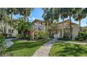 Two-story condo building with lush landscaping and brick walkways at 6450 Wild Oak Bay Blvd # 238, Bradenton, FL 34210