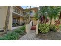 Condo entrance with stairs and tropical landscaping at 6450 Wild Oak Bay Blvd # 238, Bradenton, FL 34210