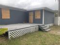 Gray mobile home with wooden deck and stairs at 6615 Sandra Dr, Port Richey, FL 34668