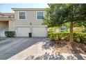 Exterior view featuring attached garages, well-maintained landscaping, and a private entrance at 6750 Fairway Gardens Dr # 6750, Bradenton, FL 34203