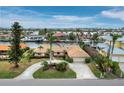 Aerial view of a waterfront home with circular driveway, lush landscaping, and boat access at 740 Old Compass Rd, Longboat Key, FL 34228