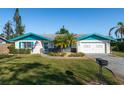 Charming single-story home with well-manicured lawn, blue trim, and attached garage at 807 62Nd W St, Bradenton, FL 34209