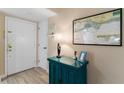 Entryway with teal cabinet, nautical map, and lamp at 1215 S Portofino Dr # 108, Sarasota, FL 34242