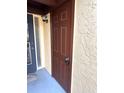 Condo's brown front door with a keypad lock, located on a yellow stucco exterior at 1318 56Th W St # 1318, Bradenton, FL 34209