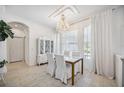 Formal dining area with stylish chandelier, white furniture, and bright natural light at 14116 Nighthawk Ter, Lakewood Ranch, FL 34202