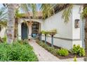 Welcoming front entry with a hanging chair, lush greenery and brick walkway at 19066 Mangieri St, Venice, FL 34293