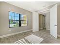 Bright bedroom featuring wood-look tile flooring and large window at 221 Brindisi Cir, Nokomis, FL 34275