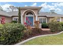 House entrance with blue door and landscaping at 4590 Oakley Rd, North Port, FL 34288