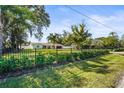 Ranch-style home with a well-manicured lawn and black fence at 504 68Th Avenue W Dr, Bradenton, FL 34207