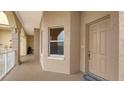 Condo hallway with tan walls, a door, and a window with blinds at 5531 Cannes Cir # 802, Sarasota, FL 34231