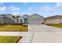 Two-story house with gray exterior, landscaping, and a paved driveway offering excellent curb appeal at 6217 116Th E Ave, Parrish, FL 34219