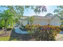 Landscaped front yard featuring a two-car garage, walkway, and mature plants at 7703 Whitebridge Gln, University Park, FL 34201