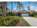 Landscaped yard and brick ranch home with a white garage door at 8009 55Th E St, Palmetto, FL 34221