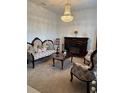 Elegant living room with a fireplace, chandelier, and ornate furniture at 10923 Blue Magnolia Ln, Parrish, FL 34219