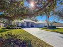 Single story house with a large tree and double car garage at 11264 28Th Street E Cir, Parrish, FL 34219