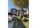 Two-story house with red siding, landscaping, and a parked SUV at 12315 Ballentrae Forest Dr, Riverview, FL 33579