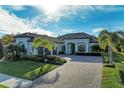 Two-story home with tile roof, paver driveway, and palm trees at 13823 Swiftwater Way, Bradenton, FL 34211