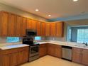 Spacious kitchen with wood cabinets and stainless steel appliances at 1910 Scarlett Ave, North Port, FL 34289