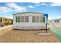 Front view of a white mobile home with green shutters and a landscaped yard at 2107 Palma Sola Blvd # 13, Bradenton, FL 34209