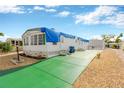 Side view of a white mobile home with a green concrete patio and gravel landscaping at 2107 Palma Sola Blvd # 13, Bradenton, FL 34209