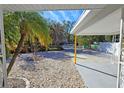 Covered patio area with gravel and tropical landscaping at 2335 Novus St, Sarasota, FL 34237