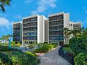 Condo building exterior showcasing landscaping and pool area at 3240 Gulf Of Mexico Dr # B104, Longboat Key, FL 34228