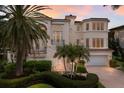 Grand two-story home with palm trees and a brick driveway at 3491 Bayou Sound, Longboat Key, FL 34228