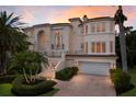 Grand two-story home with palm trees and a brick driveway at 3491 Bayou Sound, Longboat Key, FL 34228