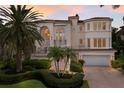 Grand two-story home with palm trees and a brick driveway at 3491 Bayou Sound, Longboat Key, FL 34228