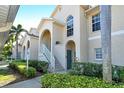 Two-story condo building with stairs, landscaping, and a blue door at 4250 Players Pl # 2615, Sarasota, FL 34238