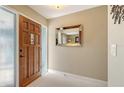 Inviting entryway with a stained wood front door with glass details, light walls, and white tiled floors at 429 N Rossetti Dr, Nokomis, FL 34275