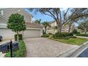 Charming home exterior featuring a brick driveway, well-maintained landscaping, and a two-car garage at 5208 Parisienne Pl # 202B33, Sarasota, FL 34238