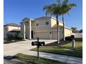 Two-story house with beige exterior, two-car garage, and palm trees at 6172 42Nd Street E St, Bradenton, FL 34203