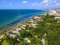 Aerial view of waterfront homes and coastline with lush vegetation at 7314 Point Of Rocks Rd, Sarasota, FL 34242