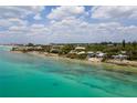 Aerial view of waterfront homes and clear, shallow ocean water at 7314 Point Of Rocks Rd, Sarasota, FL 34242