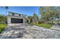 Paver driveway leading up to a contemporary home with a well-maintained lawn at 7324 Phillips St, Sarasota, FL 34243